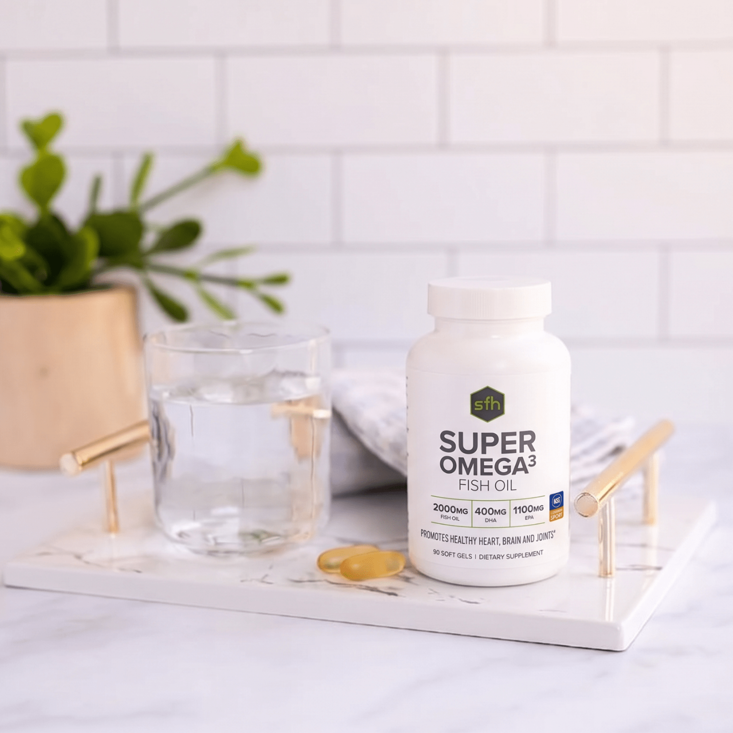 Super Omega3 fish oil supplement bottle on a white surface with a glass of water and a plant in the background.
